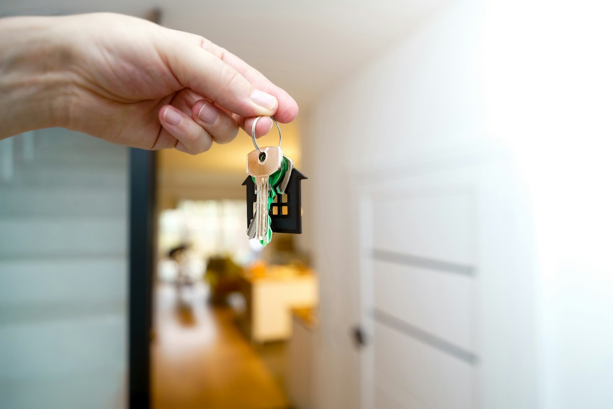 A hand holding apartment keys